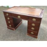 A stained Edwardian mahogany kneehole desk, with leatherette skiver above three frieze drawers,