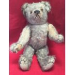 A large Edwardian plush bear, with stitched felt pads, articulated limbs and glass eyes, the snout