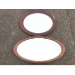 An oval bevelled mirror with inlaid cushion moulded frame; and another oval mirror with bevelled
