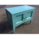 A painted washstand with panelled cupboard doors above aprons pierced with heart motifs, raised on