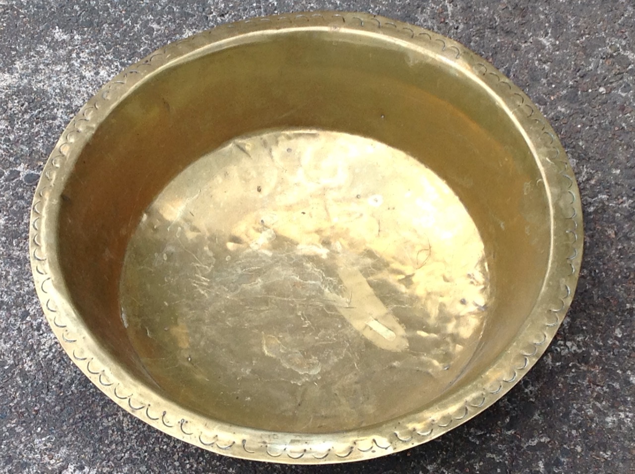 A circular brass bowl, the flat rim with hammered crescent decoration. - Image 2 of 3