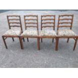 A set of four oak ladderback dining chairs, with tapestry upholstered drop-in seats, supported on