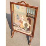 An oak framed firescreen, the woolwork tapestry panel depicting a mother with her children & dog.