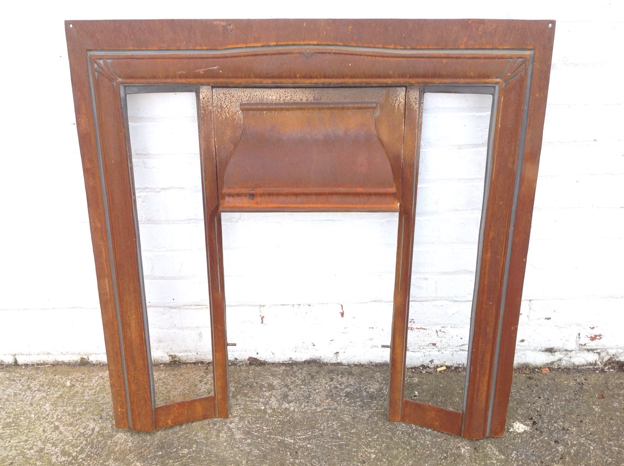 A cast iron Victorian fire insert with moulded hood, the jambs vacant for tiles.