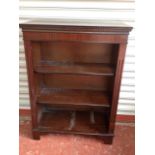 A reproduction mahogany open bookcase, the crossbanded top with dentil moulding above adjustable