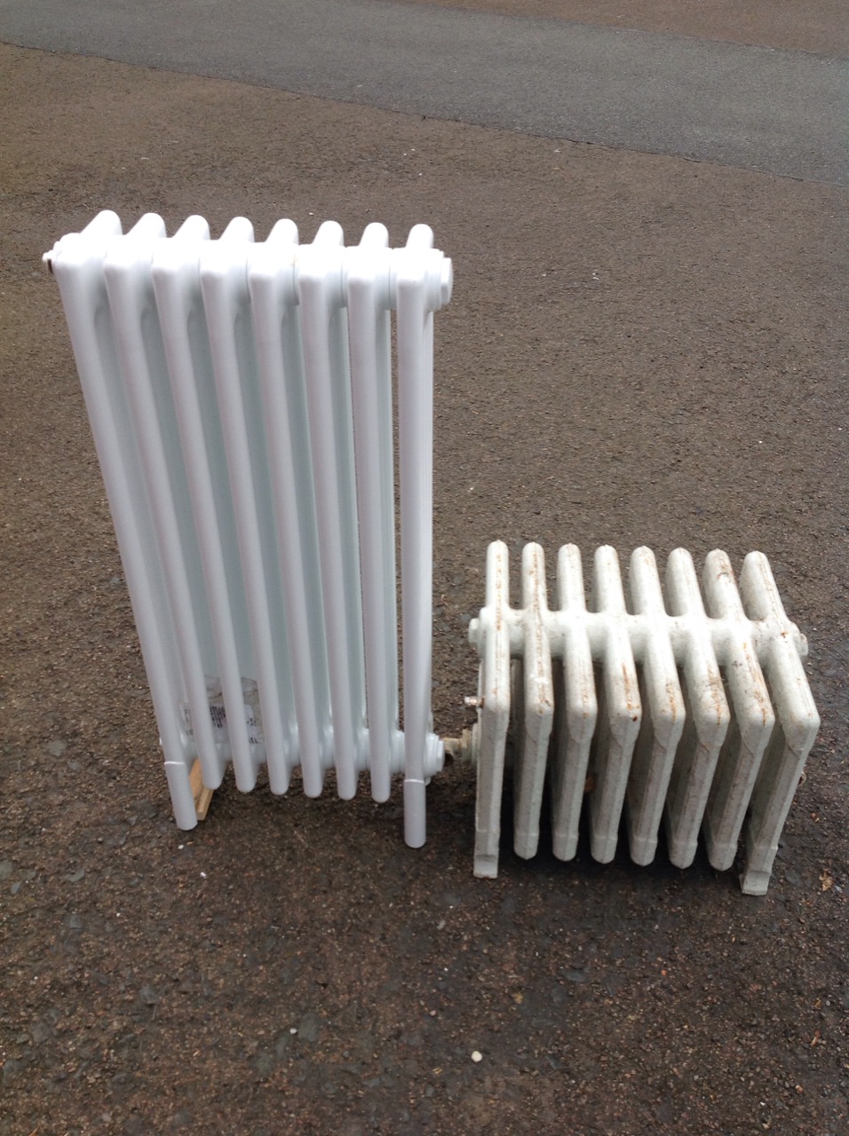 A low Edwardian cast iron radiator with eight panels; and an unused modern Victorian style