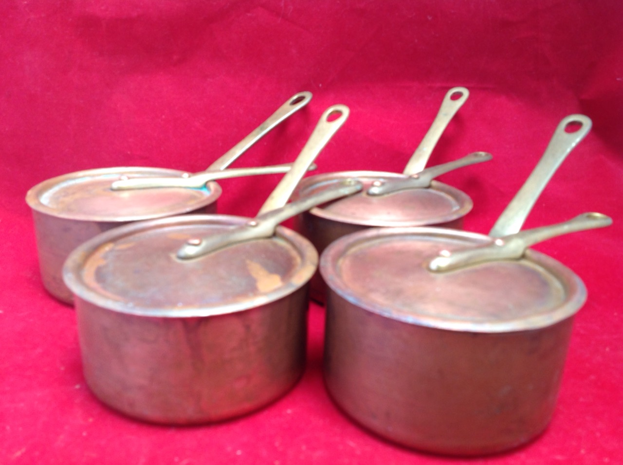 A set of four French copper pans & covers, riveted with brass handles. (4)