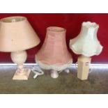 A large pale pink glazed ceramic tablelamp of twisted baluster form, mounted with tapering shade;