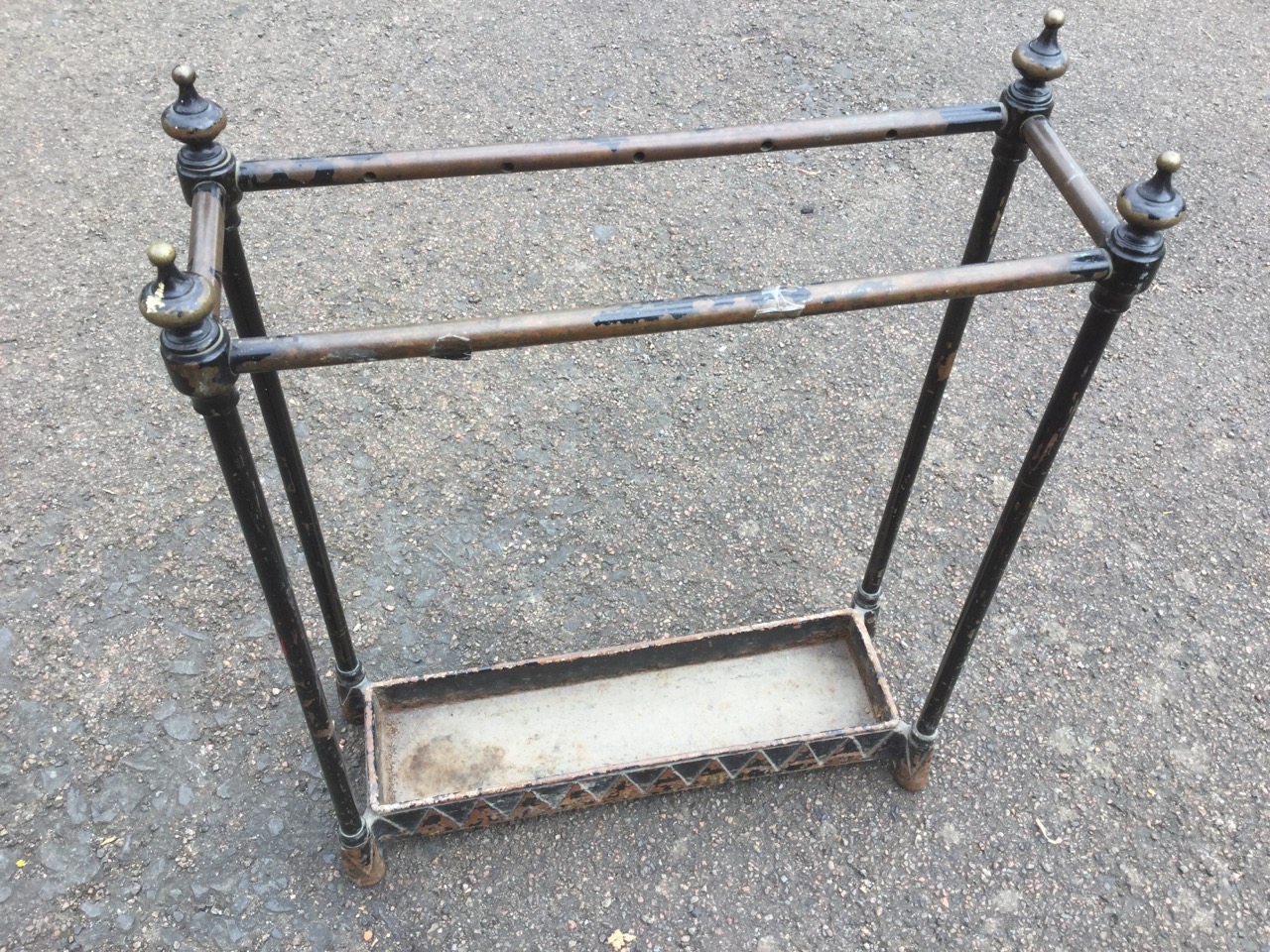 A Victorian brass stickstand, with knob finials to corners, above a rectangular drip-tray with