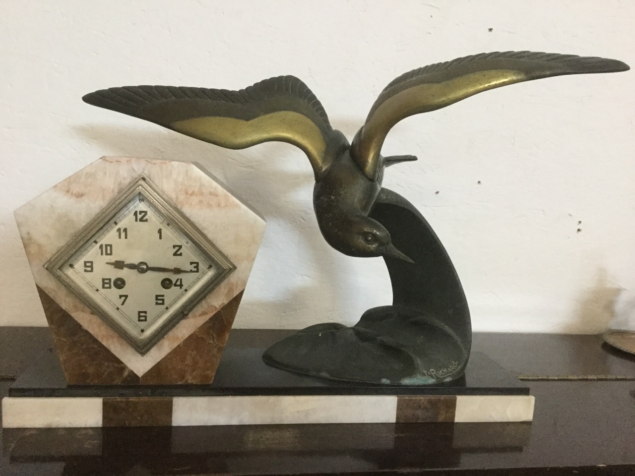 An art deco clock on marble plinth, with stylised bronzed bird signed I Rochard, the lozenge
