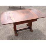 A deco oak draw-leaf dining table, the panelled top with rounded ends supported on rectangular