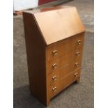 A light oak bureau, the fallfront enclosing pigeonholes above four drawers.