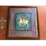 A large framed embroidered and quilted tapestry depicting a horse & rider, with leaf border.