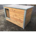 A dog kennel, the flat removable roof above a house with tongue & groove boarded sides.