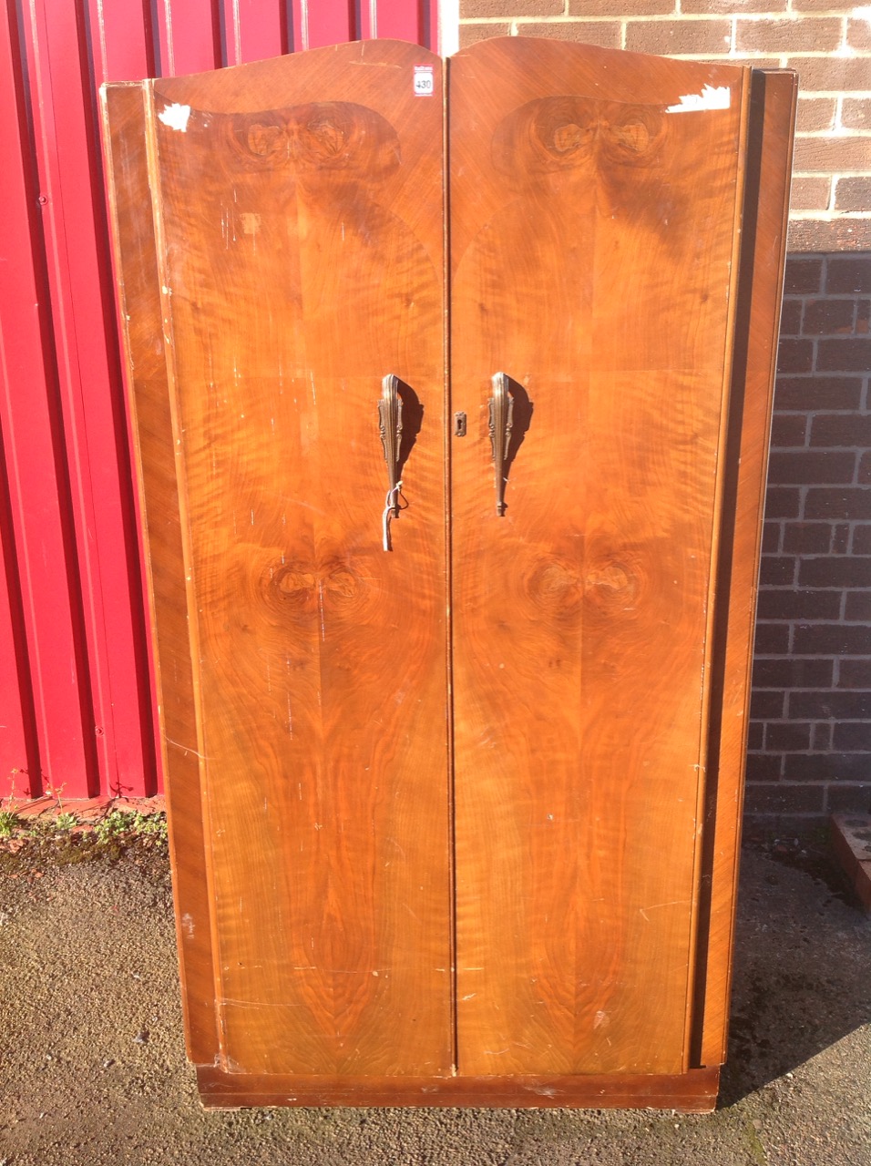 A 50s walnut wardrobe/compactum, with shaped crossbanded doors enclosing an interior with hanging