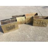 Four brass magazine racks, the front panels embossed with alehouse, galleon and classical scenes,
