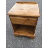 A Ducal pine bedside cabinet with rounded top above a frieze drawer and open compartment, having