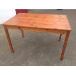 A rectangular pine table raised on square column legs.