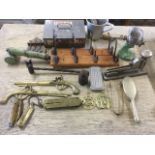 A box of miscellaneous items including rows of pegs, a mincer, four brass Salter scales, a spoon