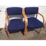 A pair of contemporary beech armchairs, with padded upholstered backs and downswept arms framing