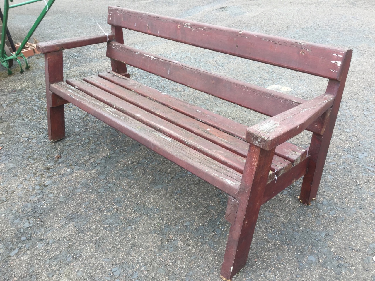 A rectangular garden bench of slatted construction, having platform arms and angled legs.