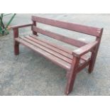A rectangular garden bench of slatted construction, having platform arms and angled legs.