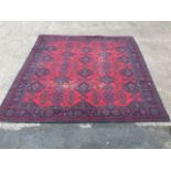 A machine woven Turkey carpet in the traditional green & blue palette on red ground - some wear.