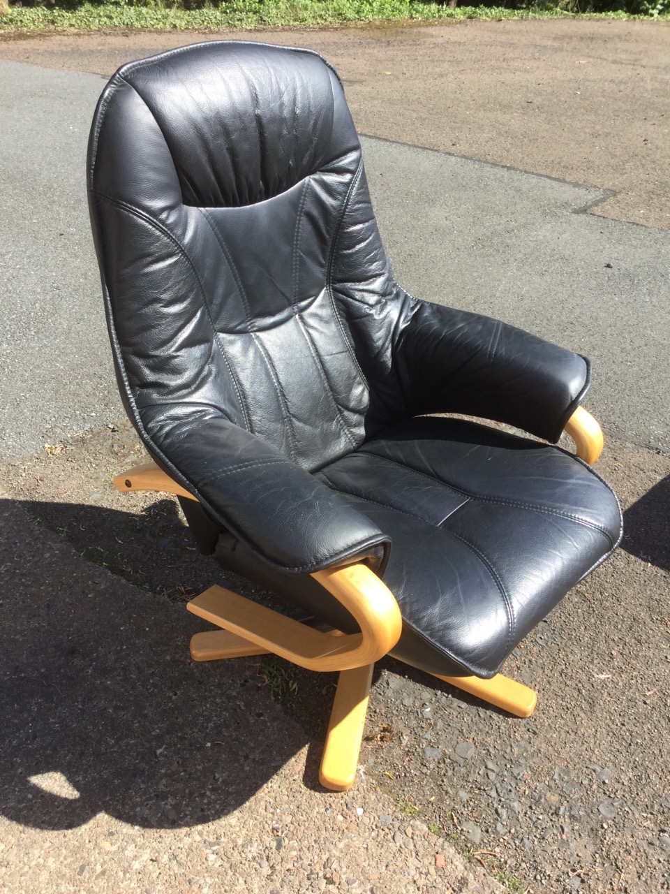 A modern leather upholstered armchair and footstool, with panelled back, seat and arms, supported on - Image 3 of 3