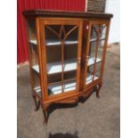 A mahogany display cabinet of angled form, having egg & dart moulding above astragal glazed doors,