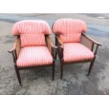 A pair of Edwardian mahogany bergere armchairs, the rounded backs above flared arms on spindles,