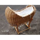 A Mothercare babies cradle, the basket with lining and mattress, on shaped rocking pine frame.