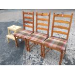 A set of three ladderback pine chairs with tartan upholstered seats raised on turned legs; and a