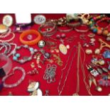 The contents of a ladies jewellery box including gilt metal chains, bangles, earrings, bead