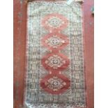 An oriental silk style rug woven with four lozenges on salmon pink field, framed by flowerhead