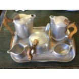 A Picquot Ware six-piece aluminium tea/coffee set with wood handles on shaped tray; a 50s black