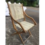 A nineteenth century beech campaign chair, the folding frame with shaped arms having canvas back &