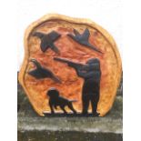 A carved panel formed from a pine tree slab, depicting shooter & dog with birds aloft, the