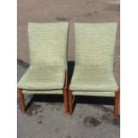 A pair of Parker Knoll easy chairs, with shaped padded backs above sprung seats, raised on turned