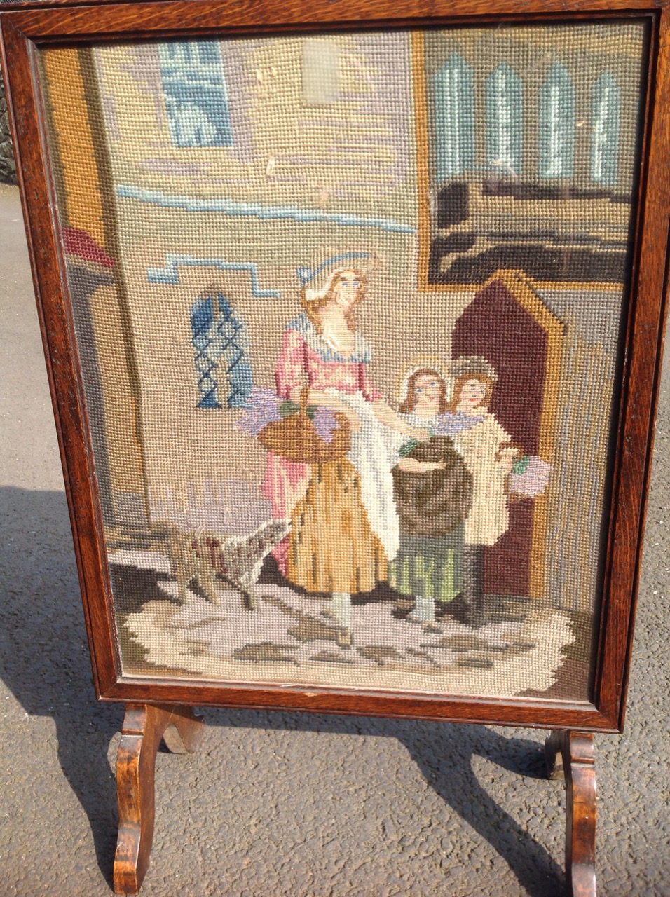 An oak framed firescreen, the woolwork tapestry panel depicting a mother with her children & dog. - Image 3 of 3