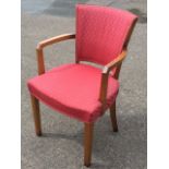 An upholstered easy chair with tapering spade shaped back above a sprung seat, with curved arms