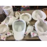 A collection of ceramic slipper pans, potties, a slop pail with cane swing handle, douche pans,