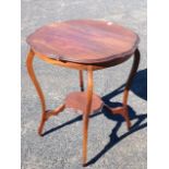 A circular walnut scalloped top occasional table, raised on tapering sabre legs joined by conforming