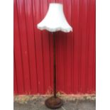 A deco oak standard lamp with graduated turned column on disc base, mounted with damask octagonal