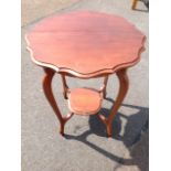 A circular mahogany occasional table, the scalloped top on shaped tapering sabre legs joined by