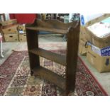 An oak open bookcase with three shelves and shaped top.