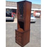 A Jaycee oak cabinet with leaded glass door framed by chisel-carved stiles above an open compartment