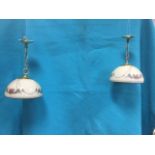 A pair of hanging lights with brass ceiling rose & chains supporting circular floral enamelled milk