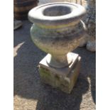 A marble urn on stand, the baluster shaped pot with wide rim raised on square plinth base,