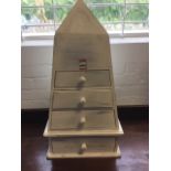 A painted pyramid style cabinet of four drawers mounted with knobs, supported on a moulded plinth.