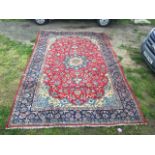 A Izmir style carpet, woven with linked floral designs and spandrels in red field,